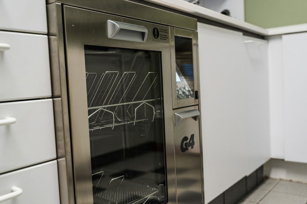 A stainless steel commercial oven with a glass door inside a kitchen.